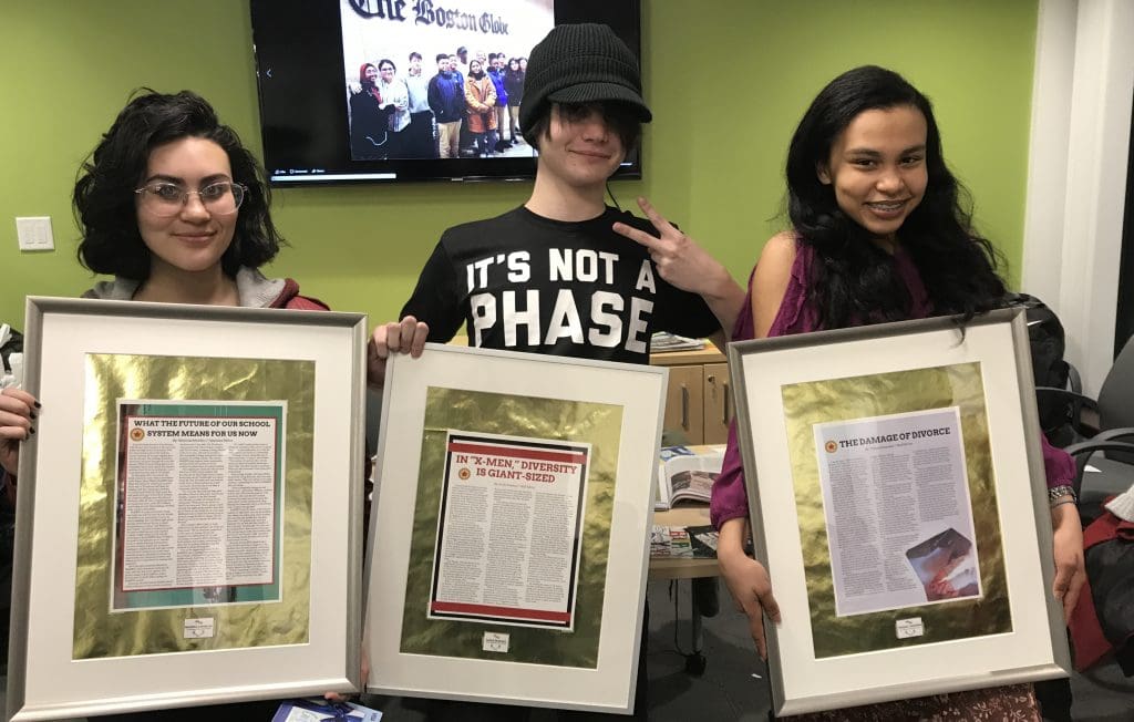 Three students holding rising voices framed awards