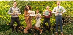 teens in print students jumping with the newspaper