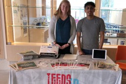 Staff Annie and Elvis standing behind table with Teens in Print materials
