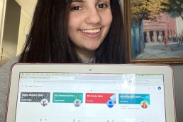 smiling student with computer showing digital classroom