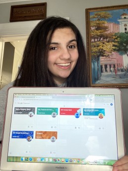 smiling student with computer showing digital classroom