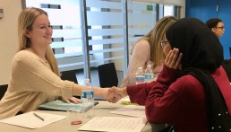 adult professional smiling and shaking hands with a student, preparing for a mock interview