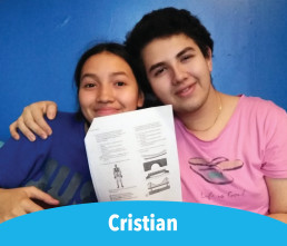 Cristian student smiling with sister holding up homework packet