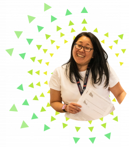 Graphic: photo of a smiling teacher with green and yellow triangles in a sunburst pattern