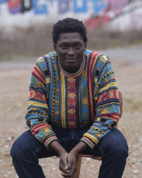 photo of Mohamed sitting down and smiling at the camera