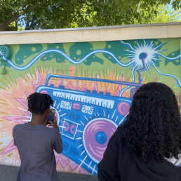 student photographs a mural during ALTAS