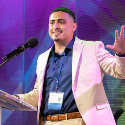 Photo of Elvis Alvarado speaking at a podium, courtesy of Johnson Photography