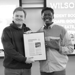 Mohamed and Graham hold a framed article